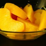 A glass bowl filled with sliced oranges on top of a table